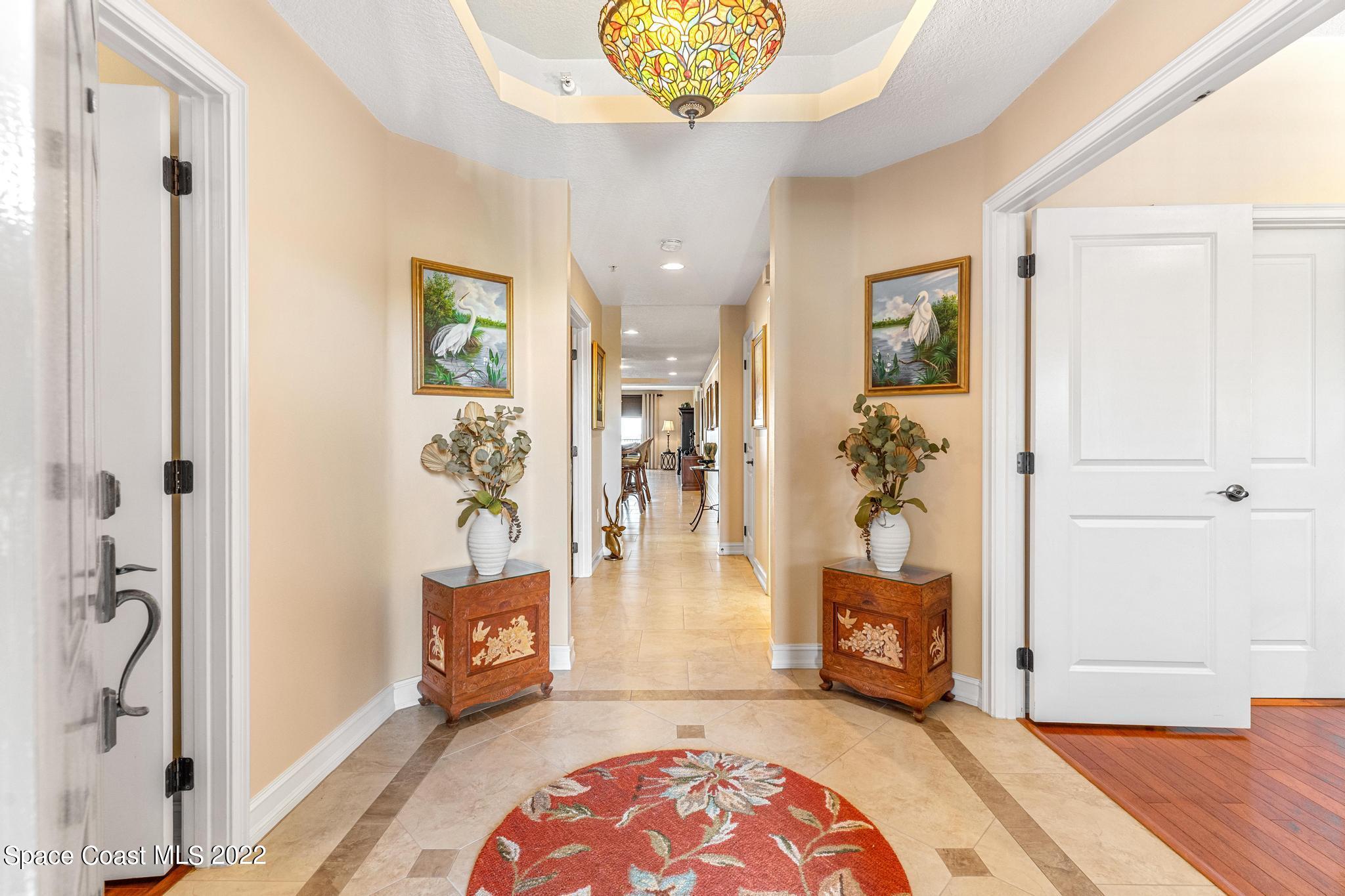 29 Riverside Drive, Unit 302 Cocoa, FL 32922 - Photo 7 of 56 a living room with furniture and a chandelier