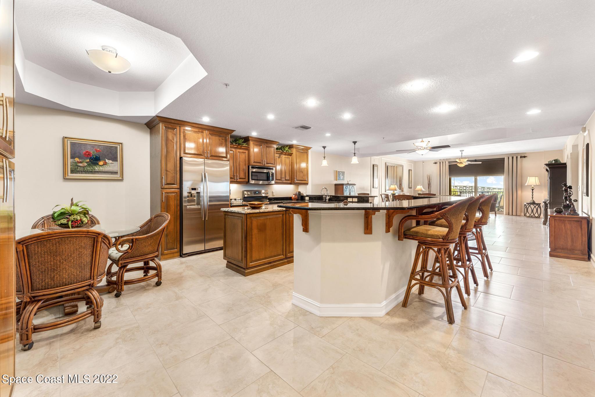 29 Riverside Drive, Unit 302 Cocoa, FL 32922 - Photo 9 of 56 a living room filled with stainless steel appliances kitchen island granite countertop a table chairs and a living room view