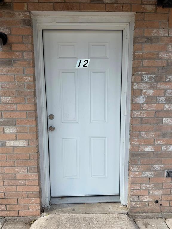 2612 West Mile 17 1/2 Road, Unit 12 Edinburg, TX 78541 - Photo 2 of 10 White paneled entry door set within a brick facade