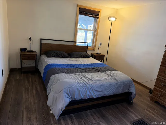 a bedroom with a bed and a flat tv screen on dresser