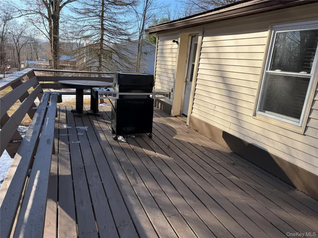 a view of a patio with table and chairs with wooden floor and fence