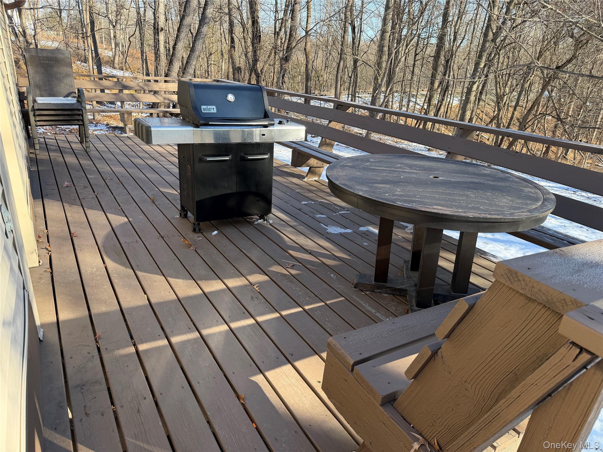 302 Lake Road New Windsor, NY 12553 - Photo 19 of 24 a view of a patio with table and chairs with wooden floor and fence