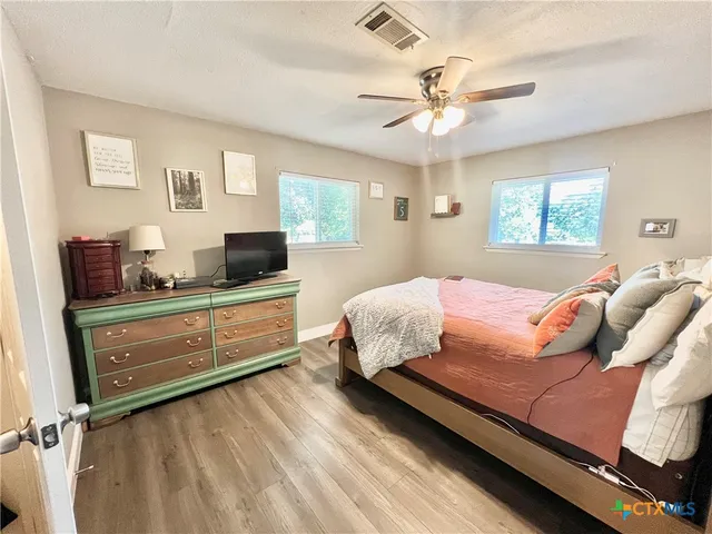 a bedroom with a bed and a chandelier fan