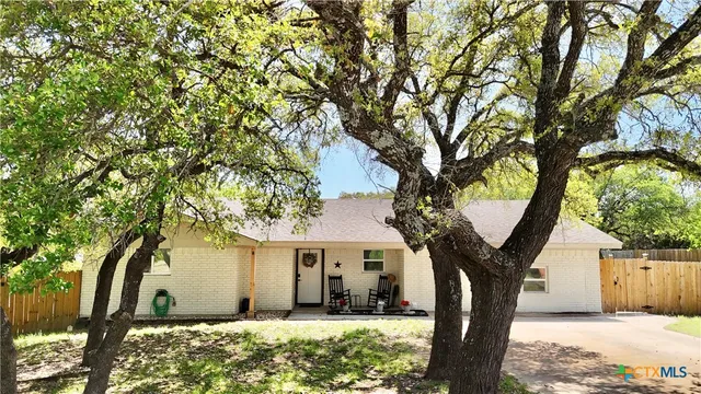 a view of a house with a tree in front of it