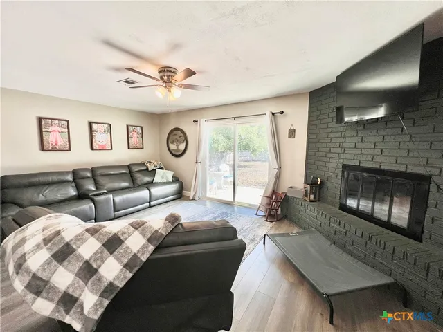 a living room with furniture large window and a fireplace