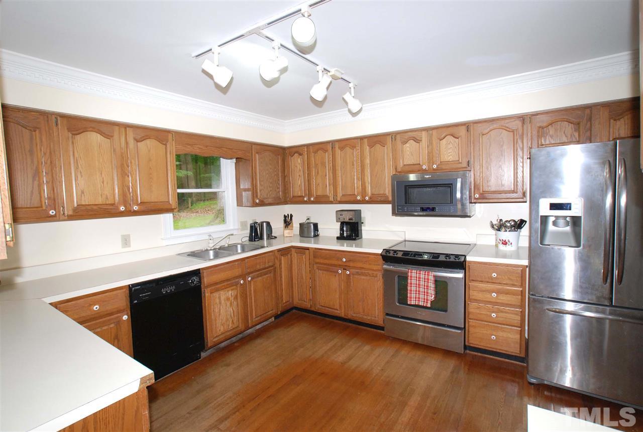 3313 Horseshoe Bend Raleigh, NC 27613 - Photo 9 of 25 a kitchen with stainless steel appliances granite countertop a refrigerator a sink dishwasher a stove and white countertops with wooden floor