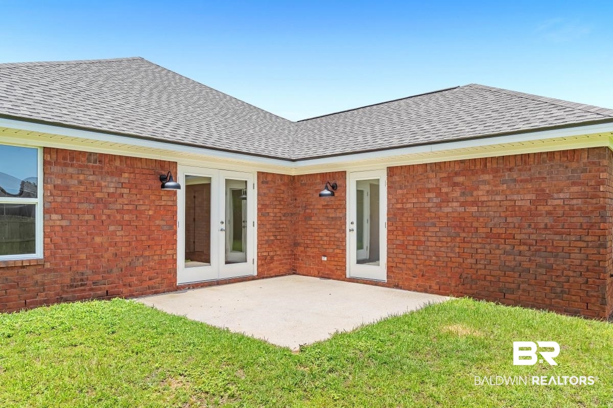 16927 Sugar Loop Foley, AL 36535 - Photo 44 of 50 Rear view of house featuring roof with shingles, brick siding, and a lawn