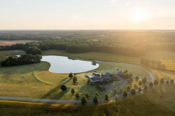 an aerial view of a house with a garden and lake view