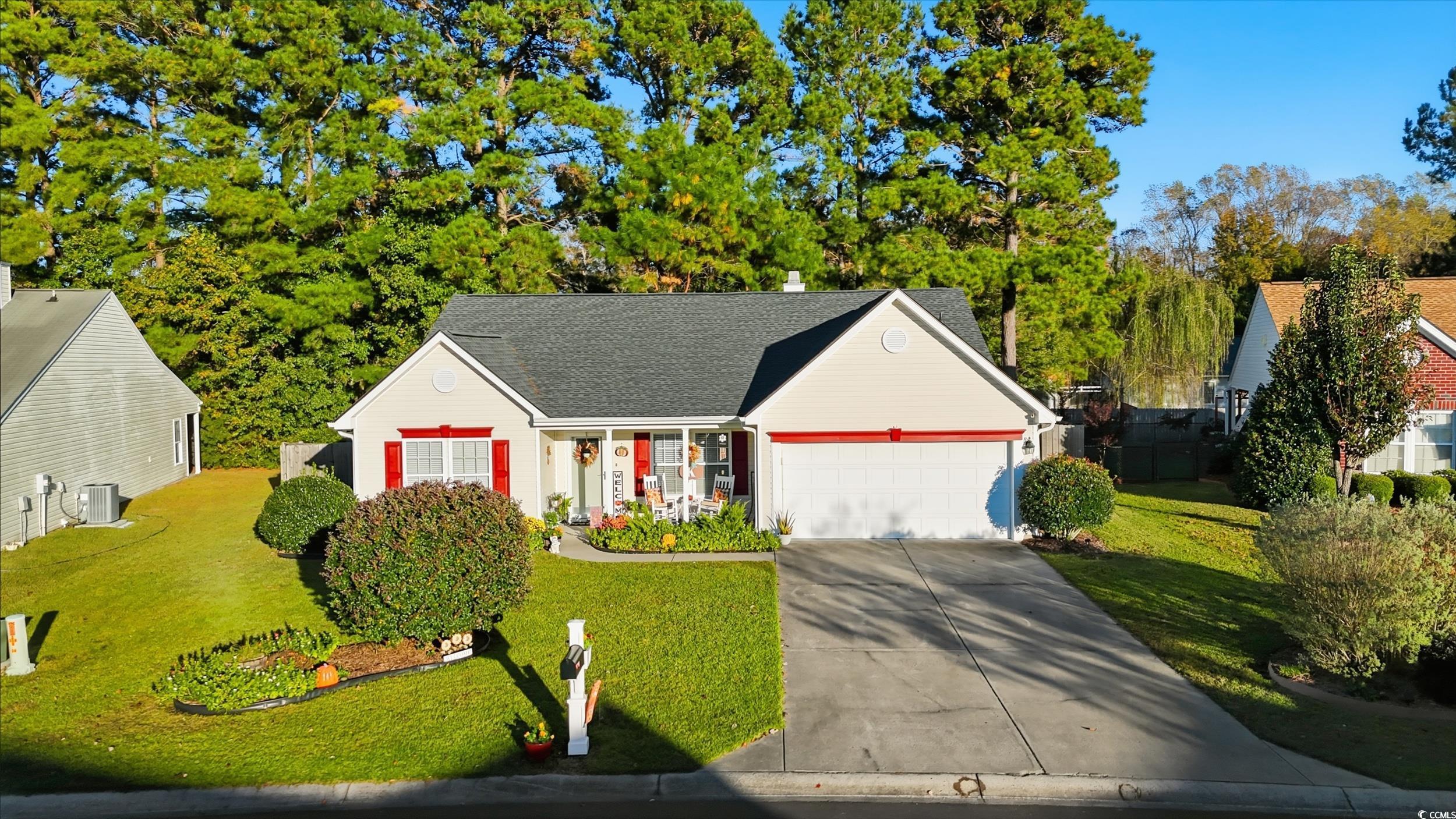 View of front of home with a front yard, concrete driveway, an attached garage, and roof with shingles