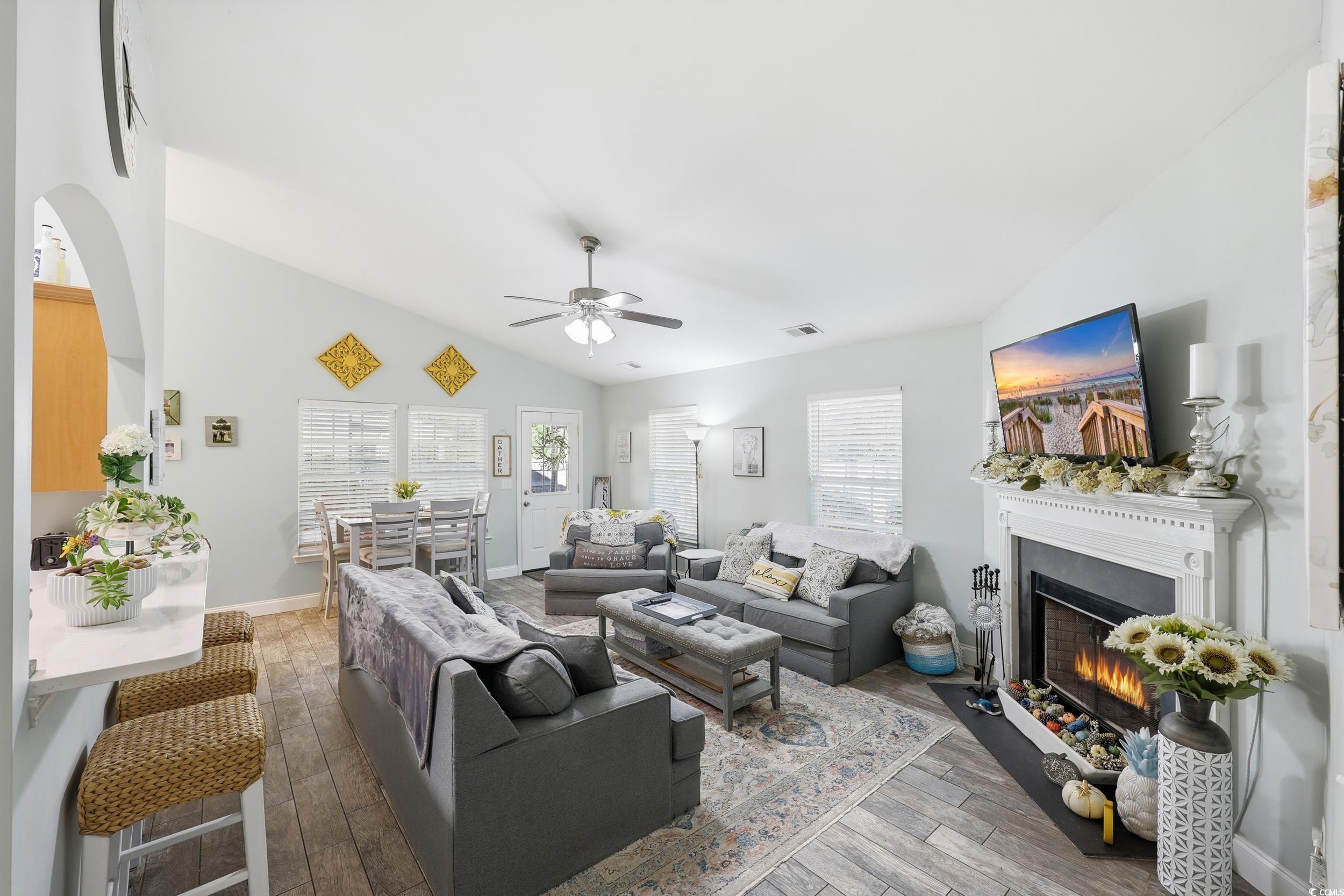 236 Devonbrook Place Longs, SC 29568 - Photo 14 of 40 Living room with vaulted ceiling, light wood finished floors, a fireplace with flush hearth, and a ceiling fan