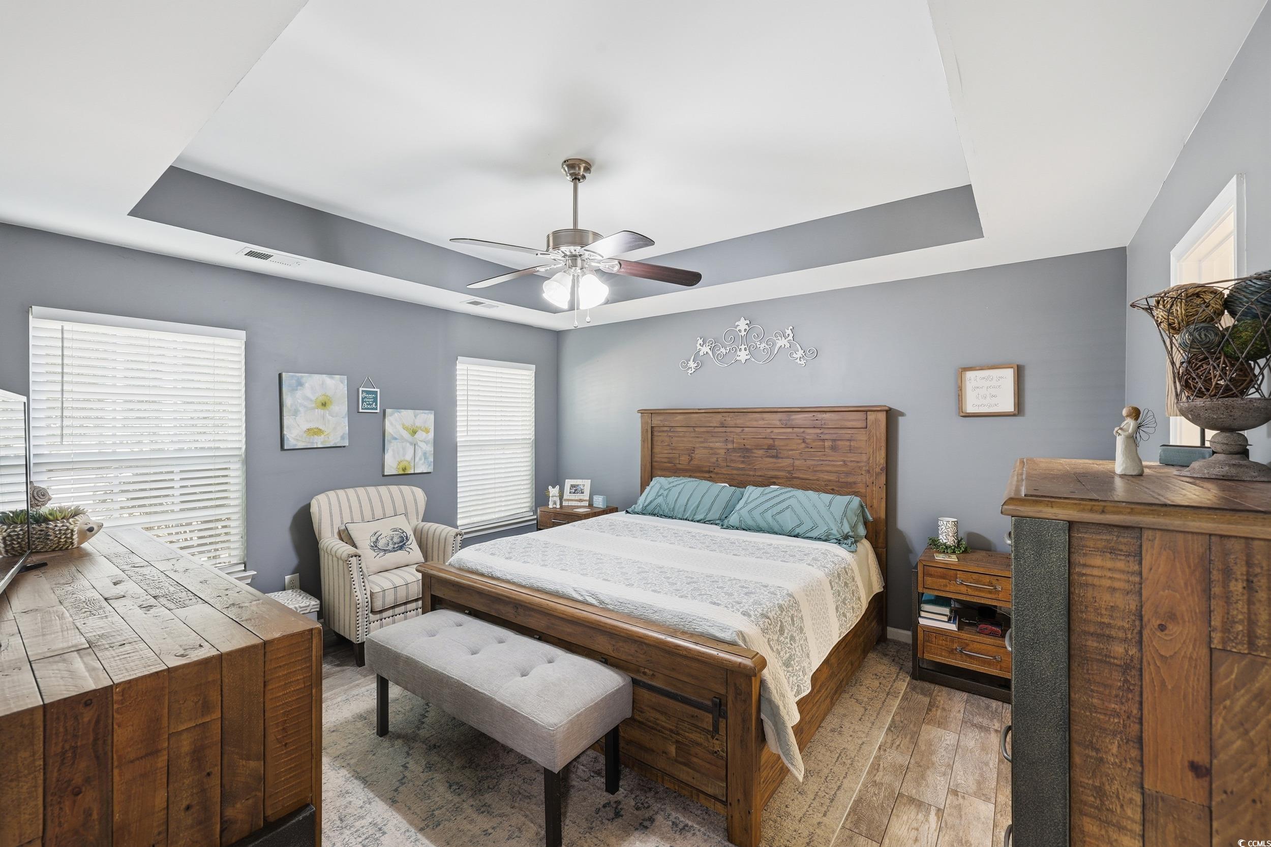 236 Devonbrook Place Longs, SC 29568 - Photo 23 of 40 Bedroom featuring a tray ceiling, hardwood / wood-style floors, and a ceiling fan