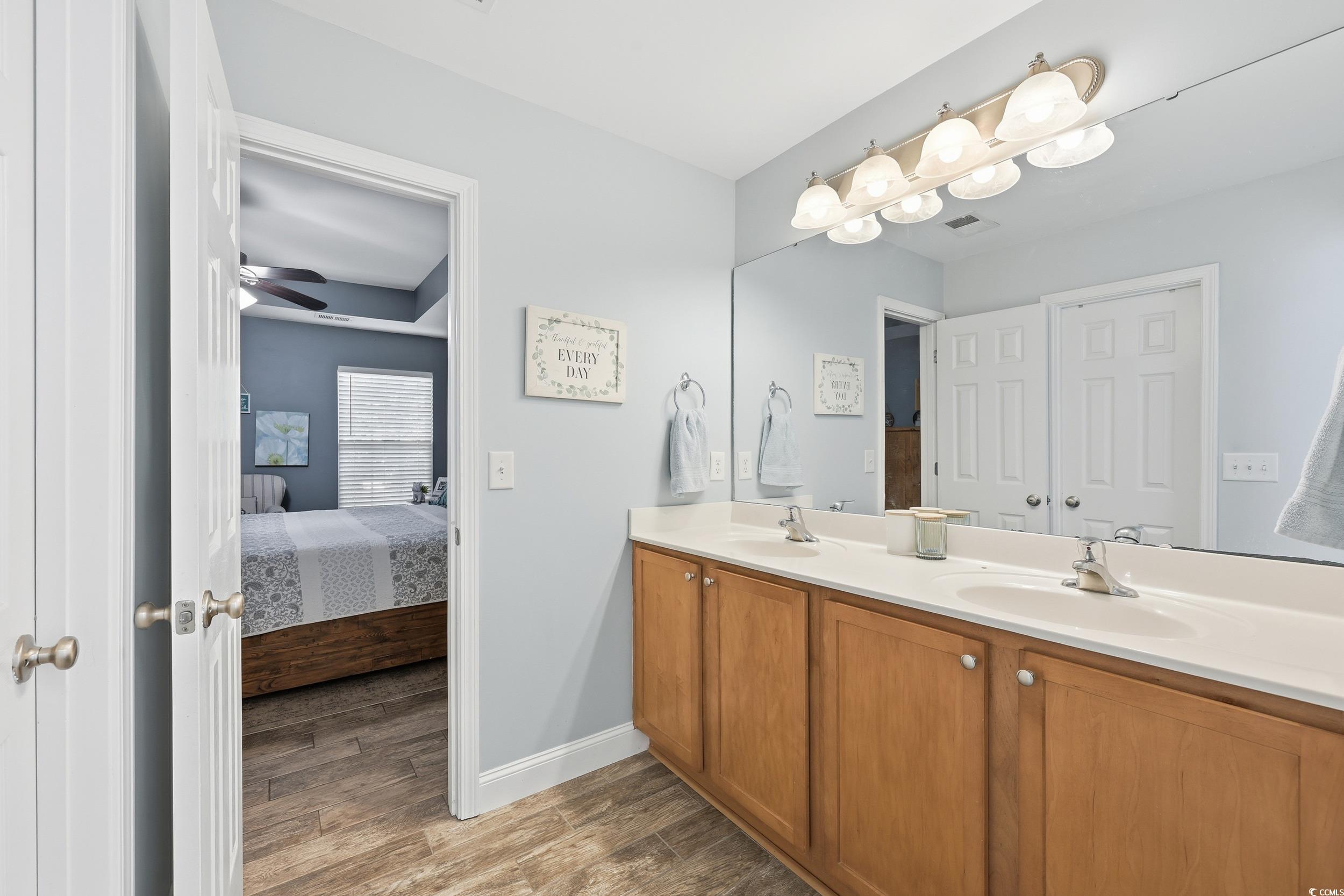 236 Devonbrook Place Longs, SC 29568 - Photo 27 of 40 Ensuite bathroom featuring double vanity, light wood finished floors, and a ceiling fan