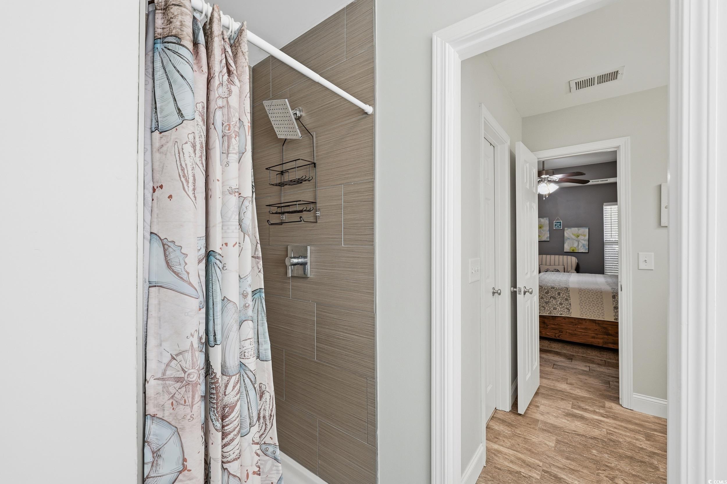 236 Devonbrook Place Longs, SC 29568 - Photo 29 of 40 Ensuite bathroom with a tile shower, light wood-style floors, and a ceiling fan