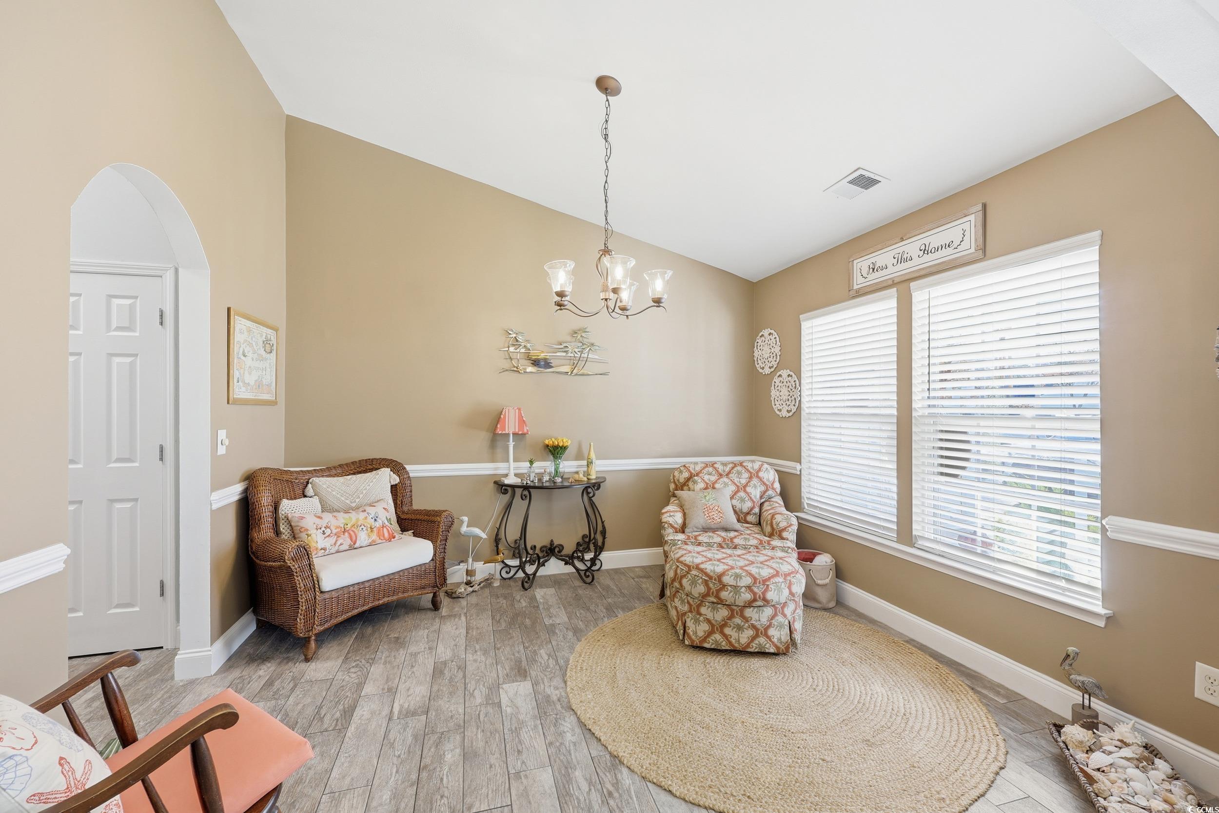 236 Devonbrook Place Longs, SC 29568 - Photo 8 of 40 Living area with vaulted ceiling, arched walkways, light wood-style floors, and a chandelier