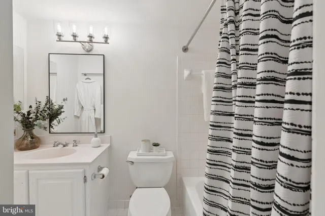 a bathroom with a sink a toilet and shower curtain