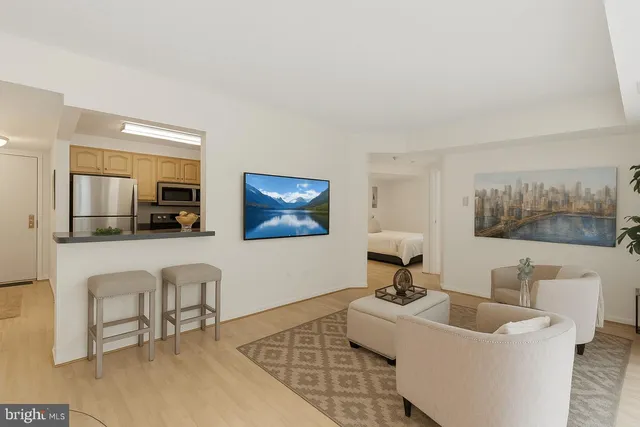 a living room with furniture and a painting on the wall