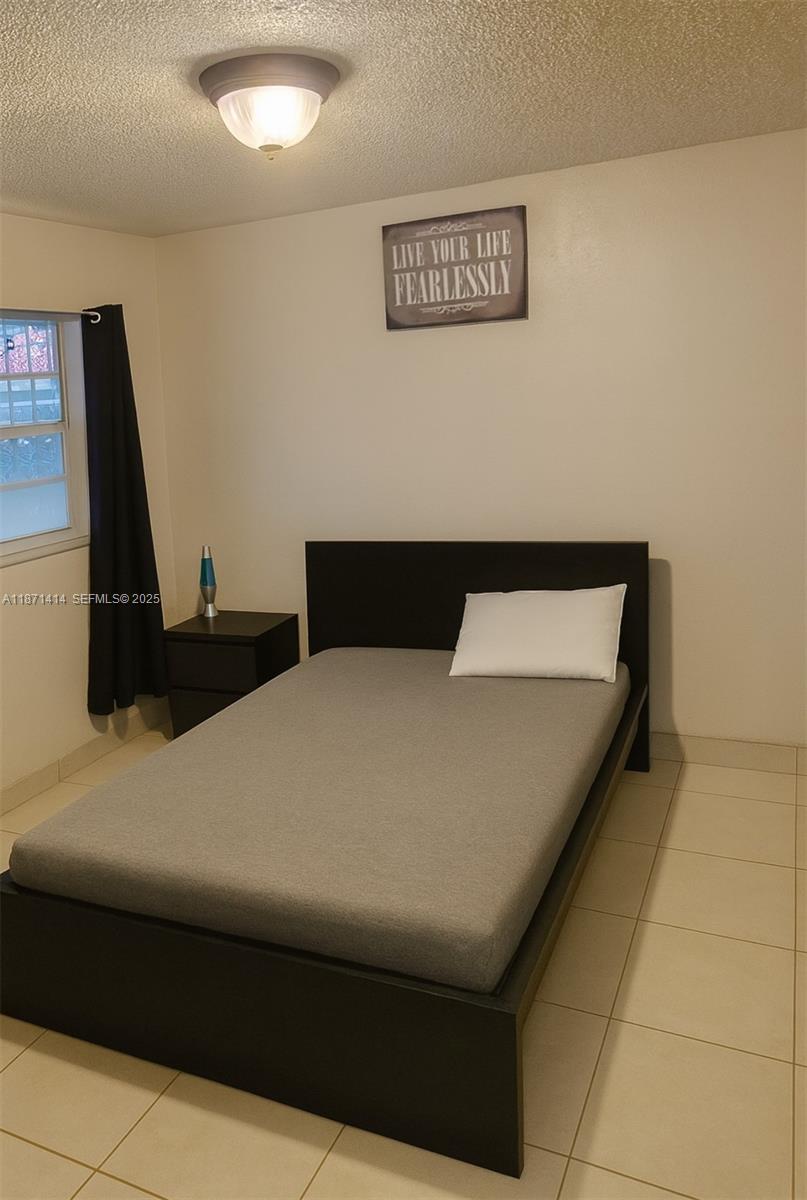 375 East Okeechobee Road Hialeah, FL 33010 - Photo 5 of 13 a bedroom with a bed and a couch