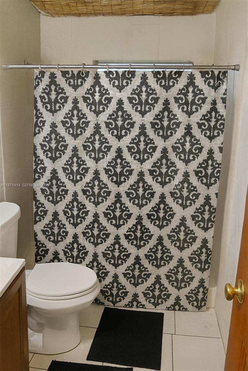 375 East Okeechobee Road Hialeah, FL 33010 - Photo 9 of 13 a bathroom with a toilet and a shower curtain