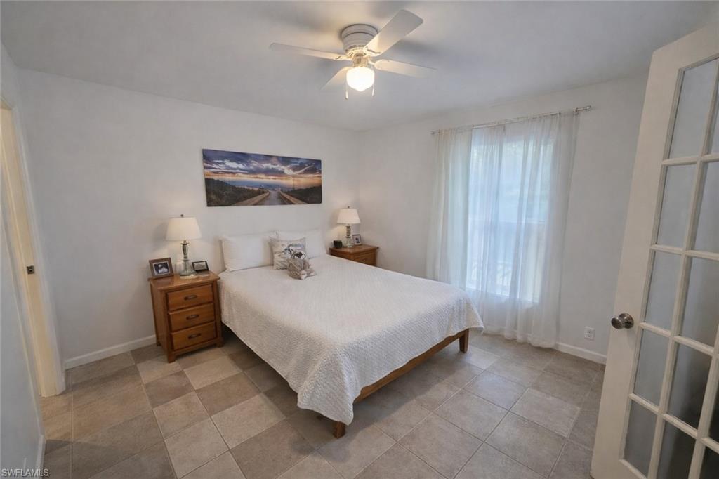 4121 8th Avenue Southeast Naples, FL 34117 - Photo 6 of 10 a bedroom with a bed and a chandelier