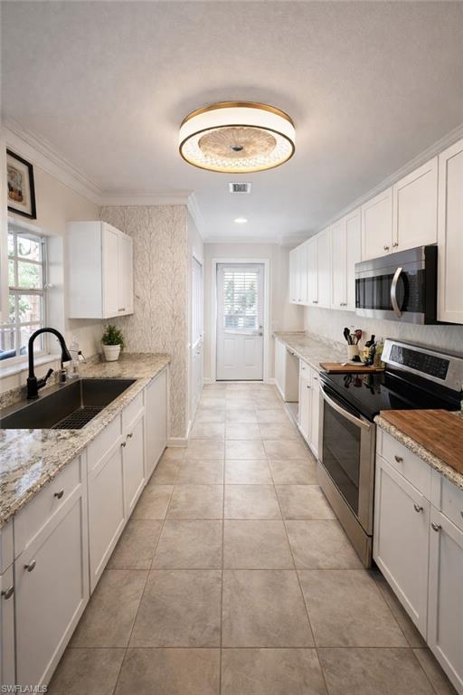 4121 8th Avenue Southeast Naples, FL 34117 - Photo 10 of 10 a large kitchen with stainless steel appliances granite countertop a sink and a stove