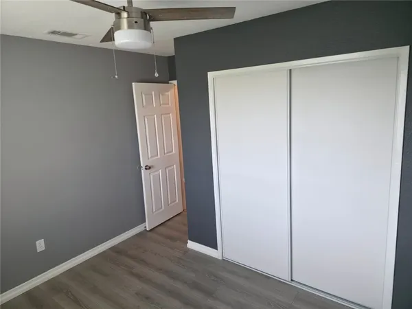 an empty room with wooden floor and entryway