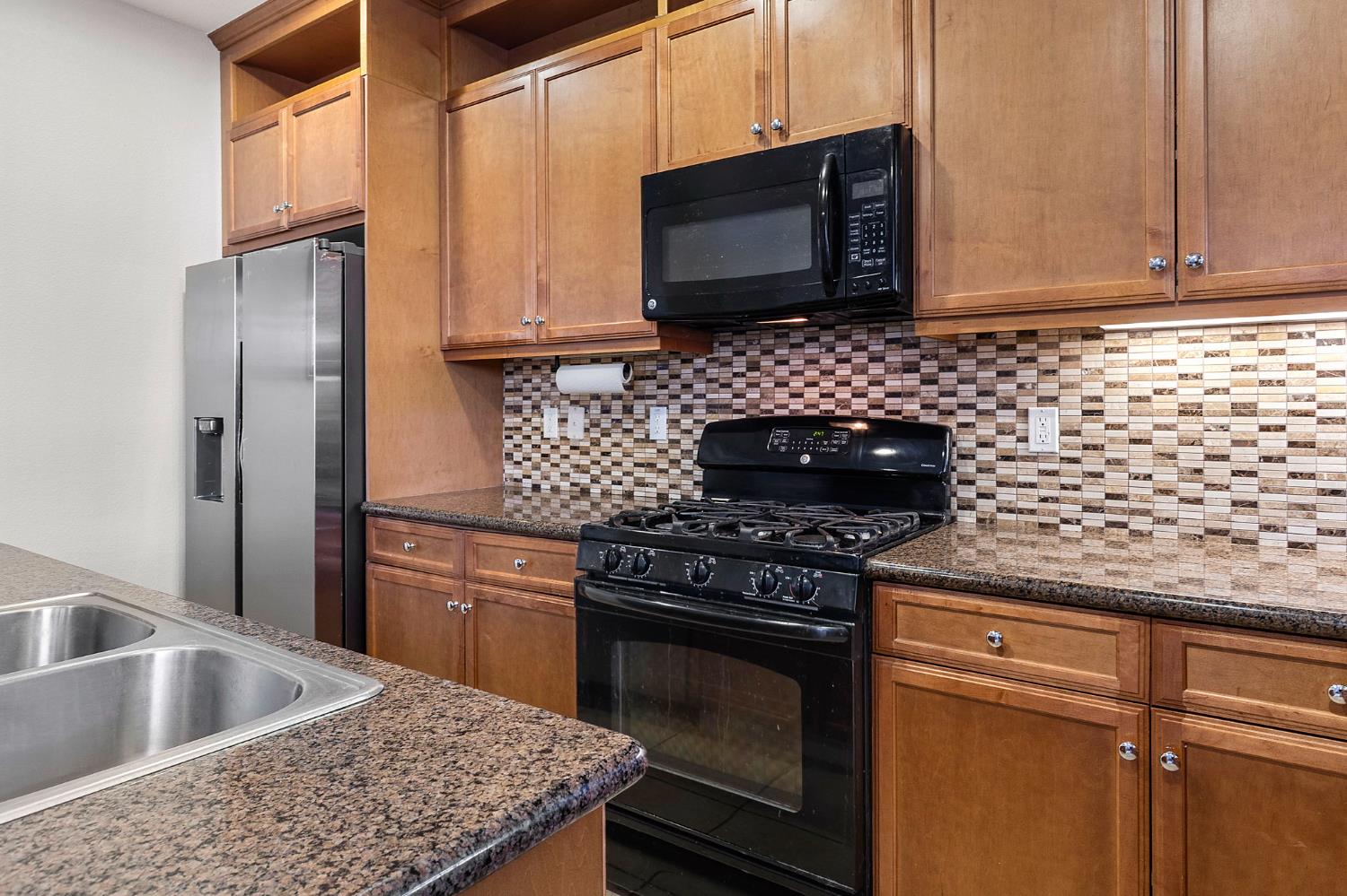 7525 Eldred Way Sacramento, CA 95829 - Photo 15 of 32 a kitchen with granite countertop wooden cabinets stainless steel appliances and a sink