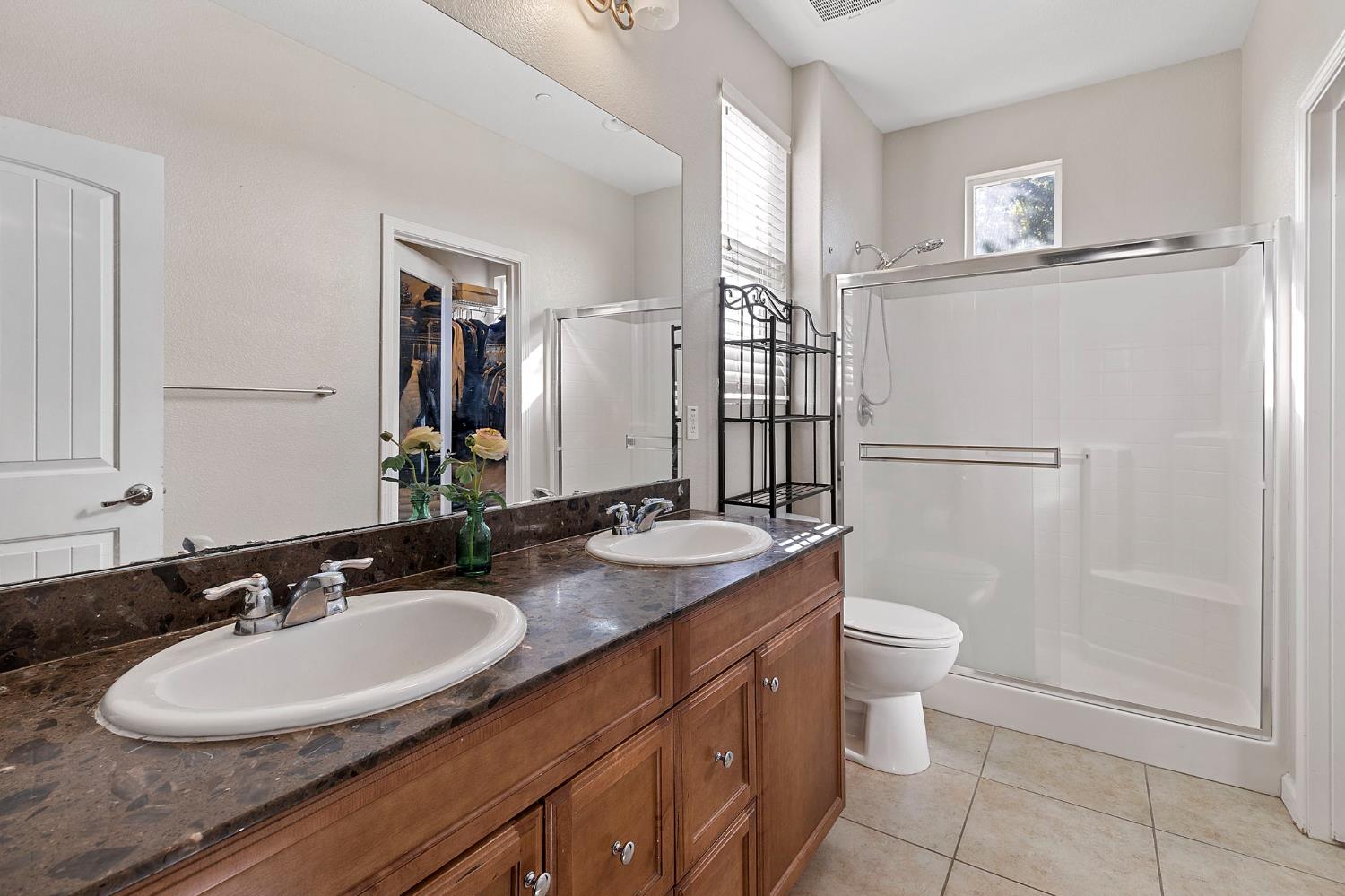 7525 Eldred Way Sacramento, CA 95829 - Photo 6 of 32 a bathroom with a granite countertop sink toilet a mirror and shower
