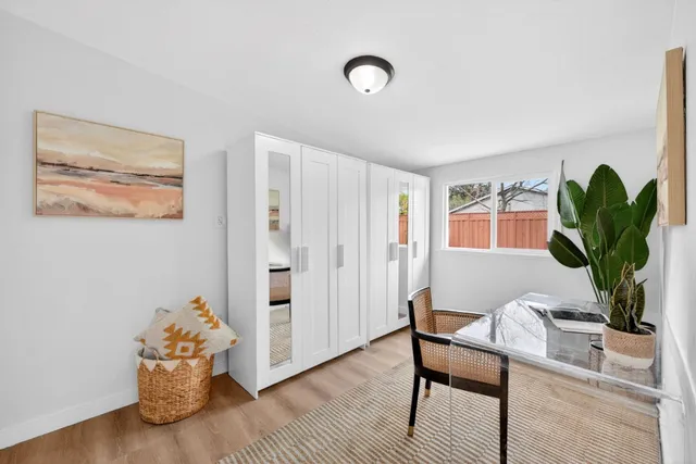 a living room with furniture flowerpot and wooden floor