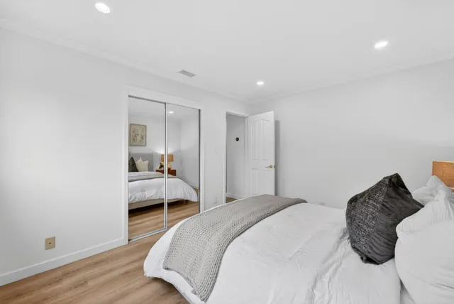 a bedroom with a bed and a view of living room