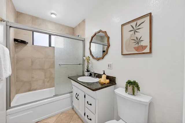 a bathroom with a granite countertop sink a toilet and a bathtub