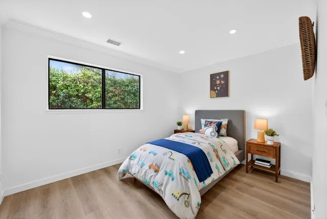 a bedroom with a bed and a painting on the wall