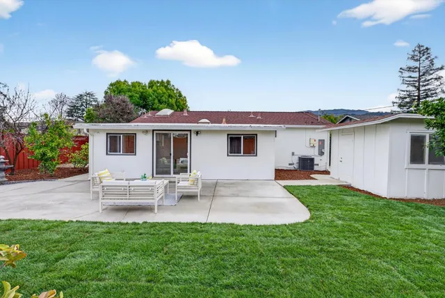 a view of a house with a backyard and a patio