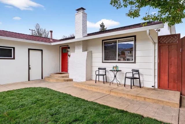 a view of a house with a patio and a yard