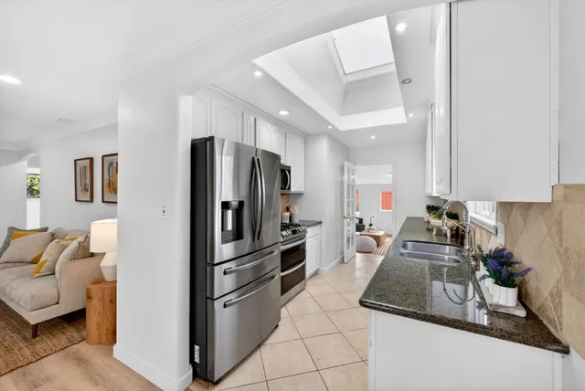 a kitchen with stainless steel appliances granite countertop a refrigerator and a sink