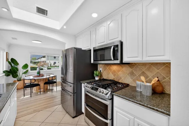 a kitchen with granite countertop a stove and a refrigerator