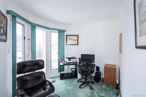 a view of a livingroom with workspace and a window