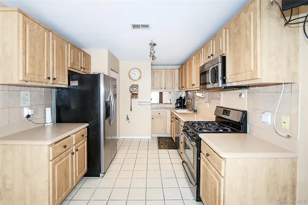 a kitchen with stainless steel appliances granite countertop a refrigerator a stove a sink and a microwave