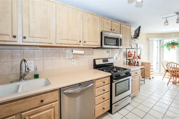 a kitchen with granite countertop white cabinets stainless steel appliances and sink