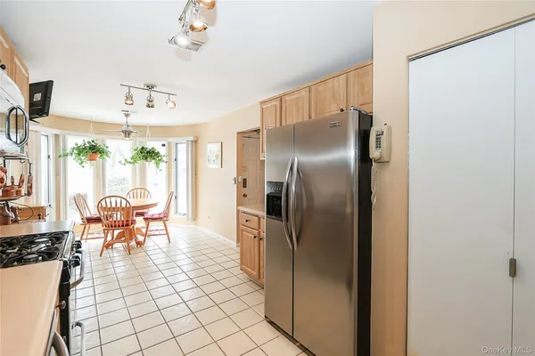 a dining room with stainless steel appliances a refrigerator and cabinets