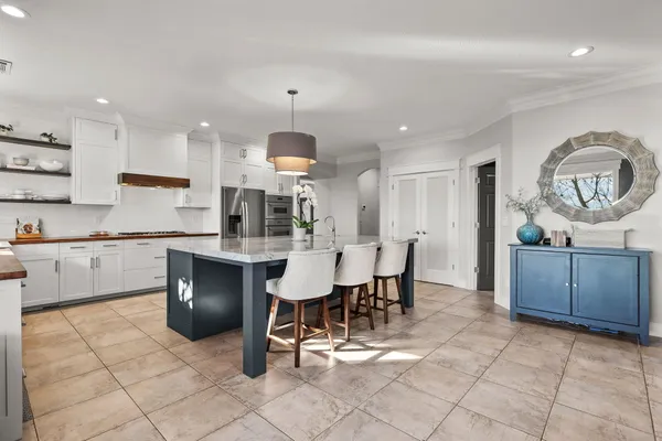a kitchen with granite countertop white cabinets and stainless steel appliances