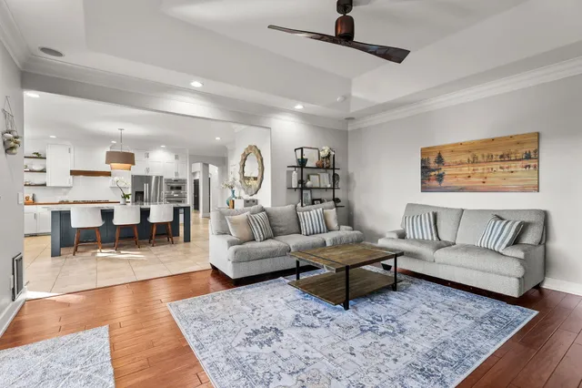 a living room with furniture wooden floor and a large window