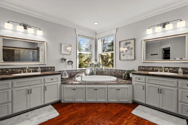 a bedroom with a bed a desk and chair with wooden floor