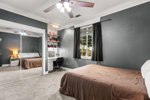 a bedroom with a bed a chair and a potted plant