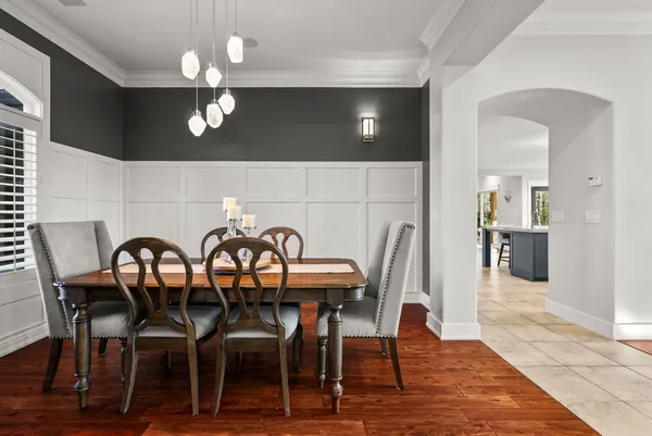 a kitchen with stainless steel appliances a dining table chairs and refrigerator