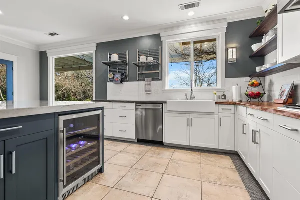 a kitchen with stainless steel appliances granite countertop a sink a stove a dining table and chairs with wooden floor