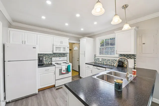 a kitchen with stainless steel appliances granite countertop a refrigerator sink and stove