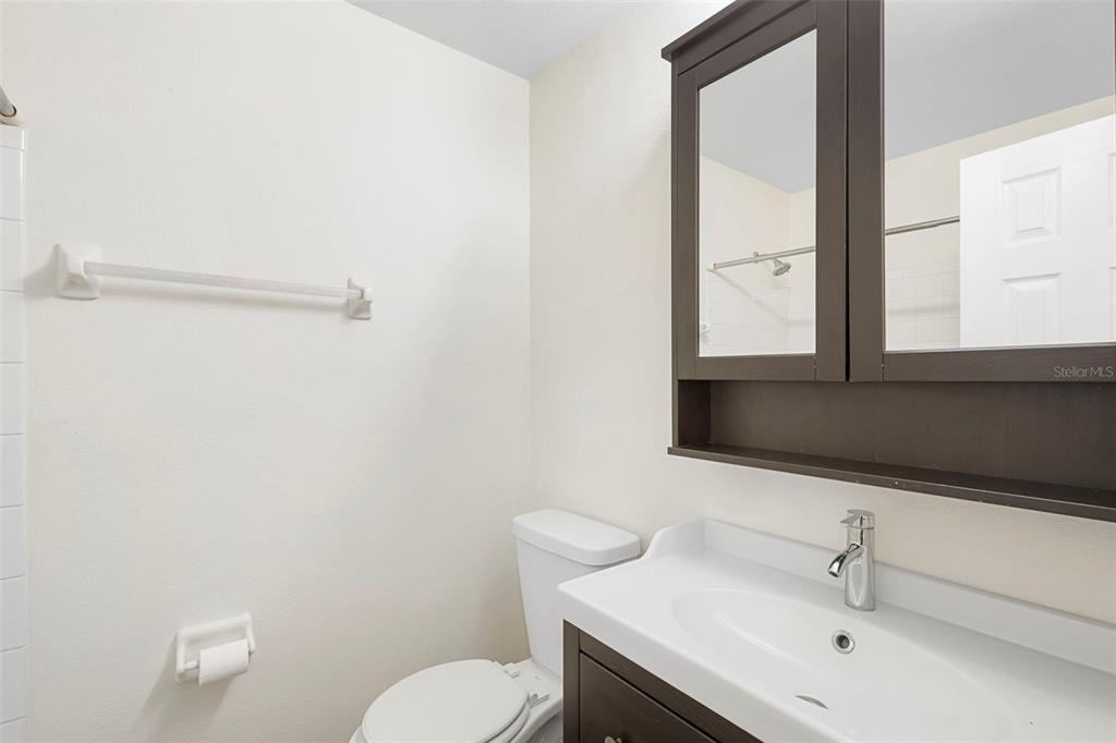 949 Tillery Way, Unit 101 Orlando, FL 32828 - Photo 21 of 38 a bathroom with a toilet sink and mirror