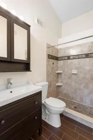a bathroom with a sink a toilet and shower
