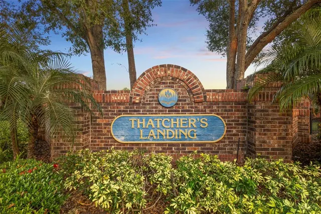 a view of sign board with buildings in the background