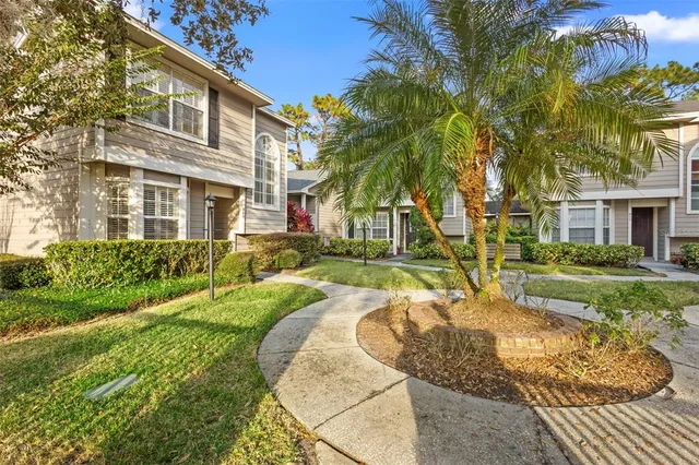 a view of a house with a big yard plants and large trees